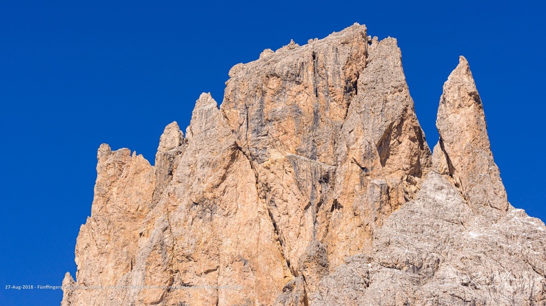 The Fünffingerspitze (Five Finger Peak, Punta delle Cinque Dita), so called because the five summits of this mountain form the shape of a hand with five fingers. The middle finger is the highest point with the summit (2918 meter) of the Fünffingerspitze. The thumb stands a bit isolated. Close-up of the Fünffingerspitze (Cinque Dita), part of the Langkofel Group mountain massif