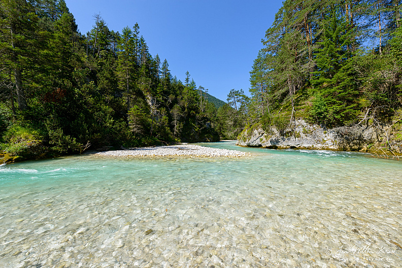 The Isar river flows from its source in the Hinterautal valley towards the village Scharnitz