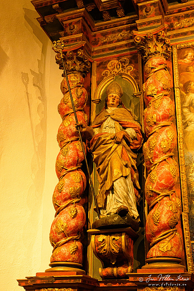 Carved bishop saint with mitre and crozier on an ornate religious retable at Longeborgne.