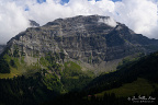 Stratified Limestone Massif in the Vaud Alps (10 visits) A broad wall of horizontally layered limestone rises above dark conifer forest and alpine pasture. Stratified Limestone Massif in the Vaud Alps