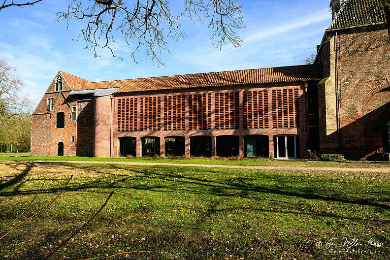 Rebuilt west wing of Klooster Ter Apel, with a contemporary red slatted facade attached to older brick monastery buildings.